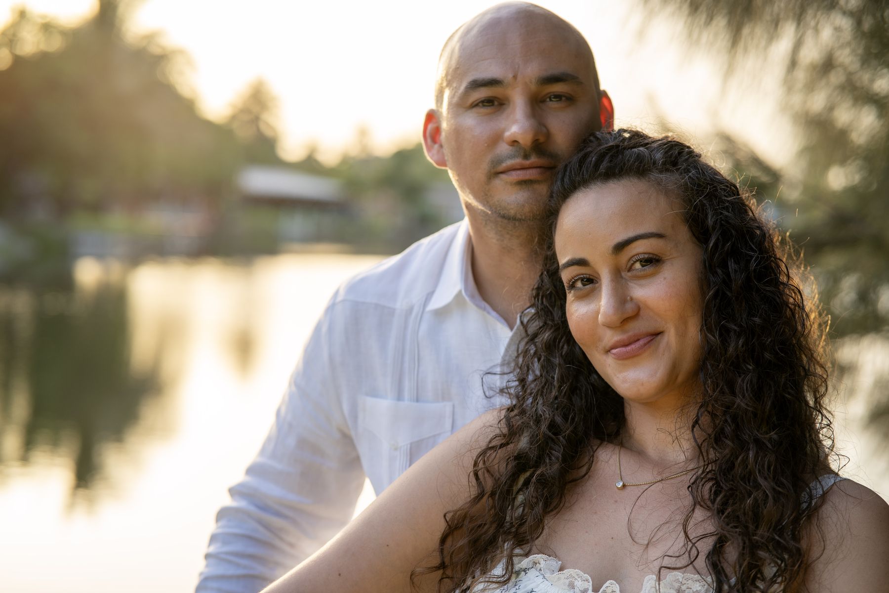 Couple standing close together by the lakeshore