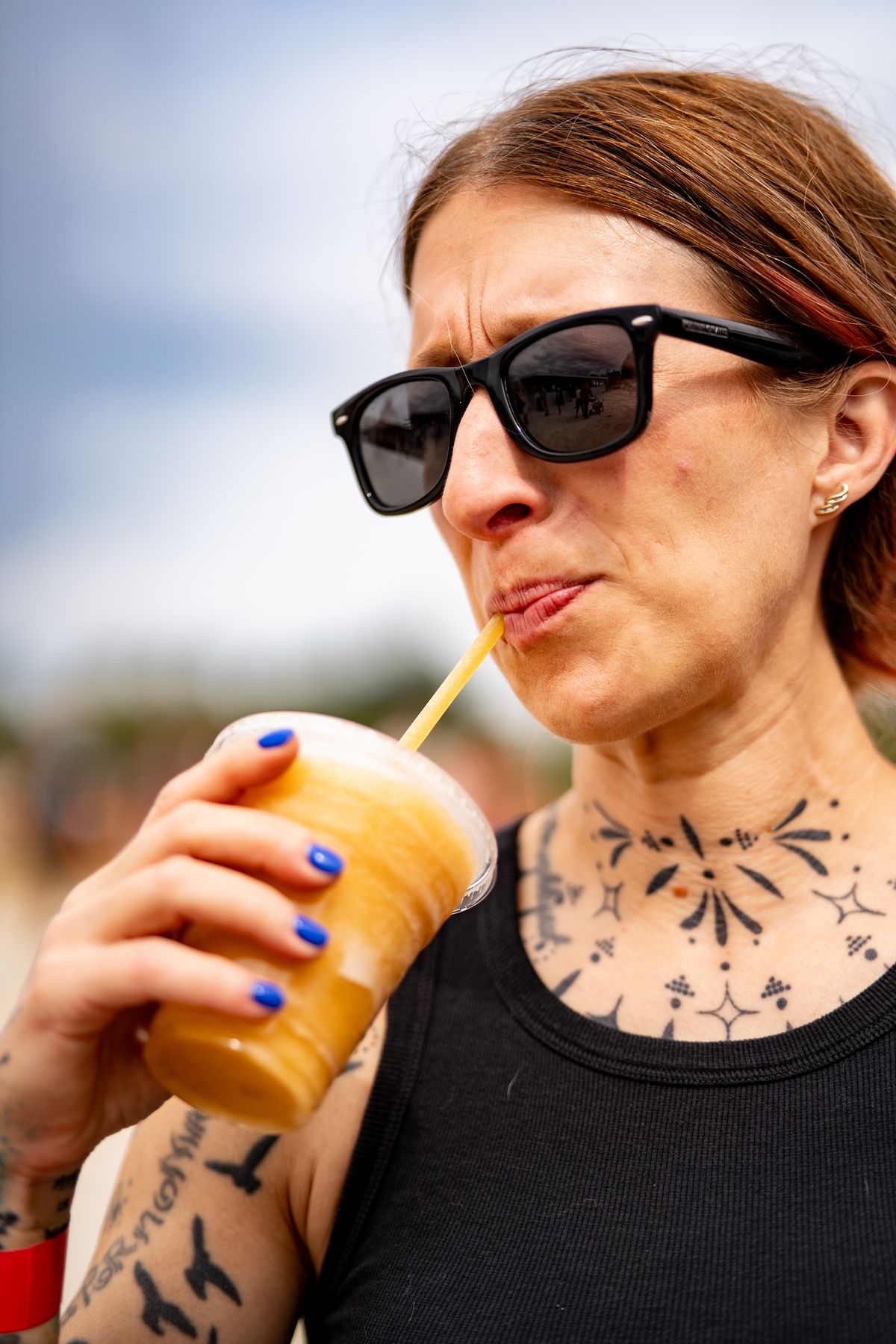 Candid outdoor portrait of a tattooed woman in sunglasses
