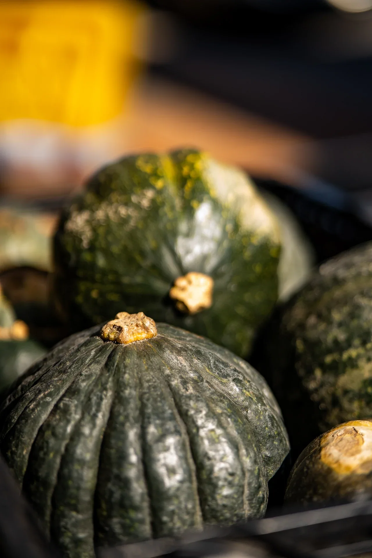 Dark green squash arranged beside a market stall