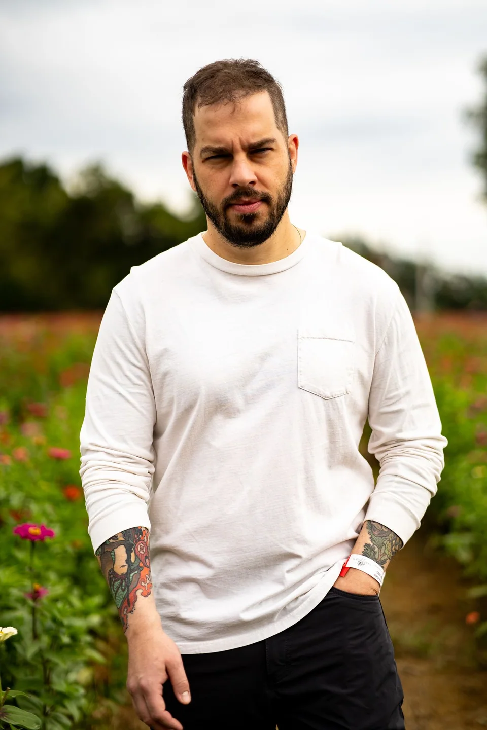 Outdoor portrait of a tattooed man in a flower field