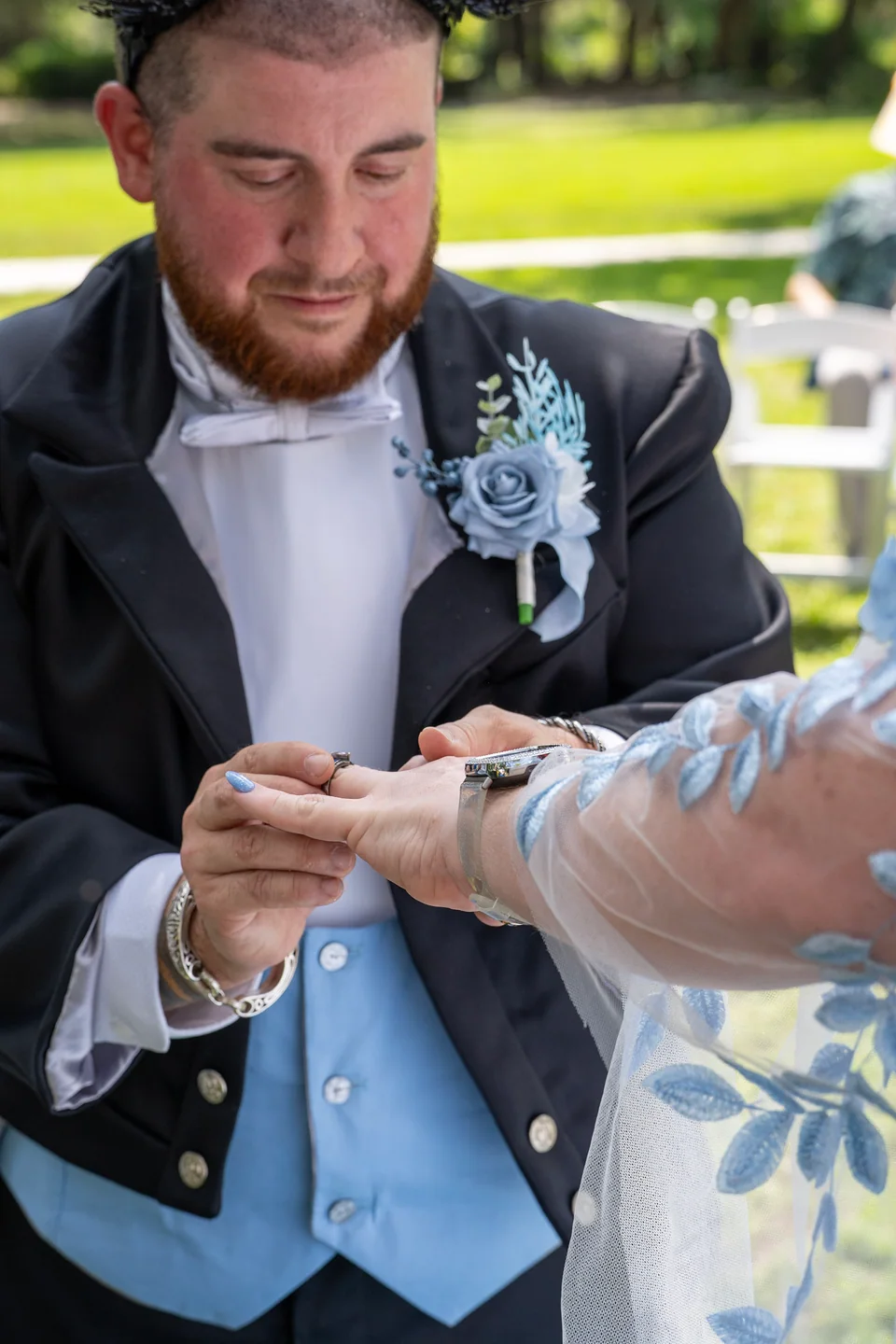 Hands and rings photographed closely during an outdoor wedding ceremony
