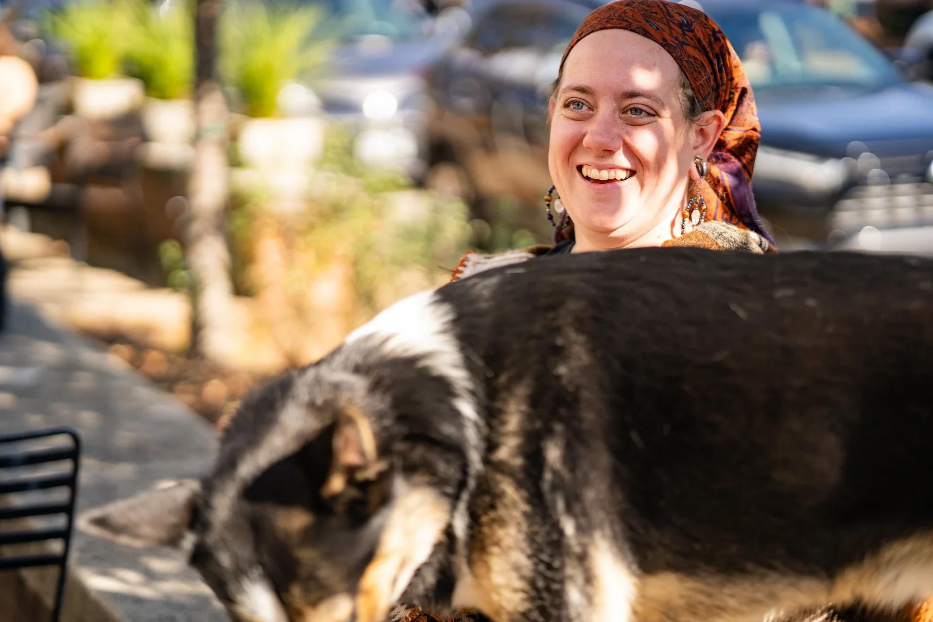 A smiling person with a large dog in the foreground