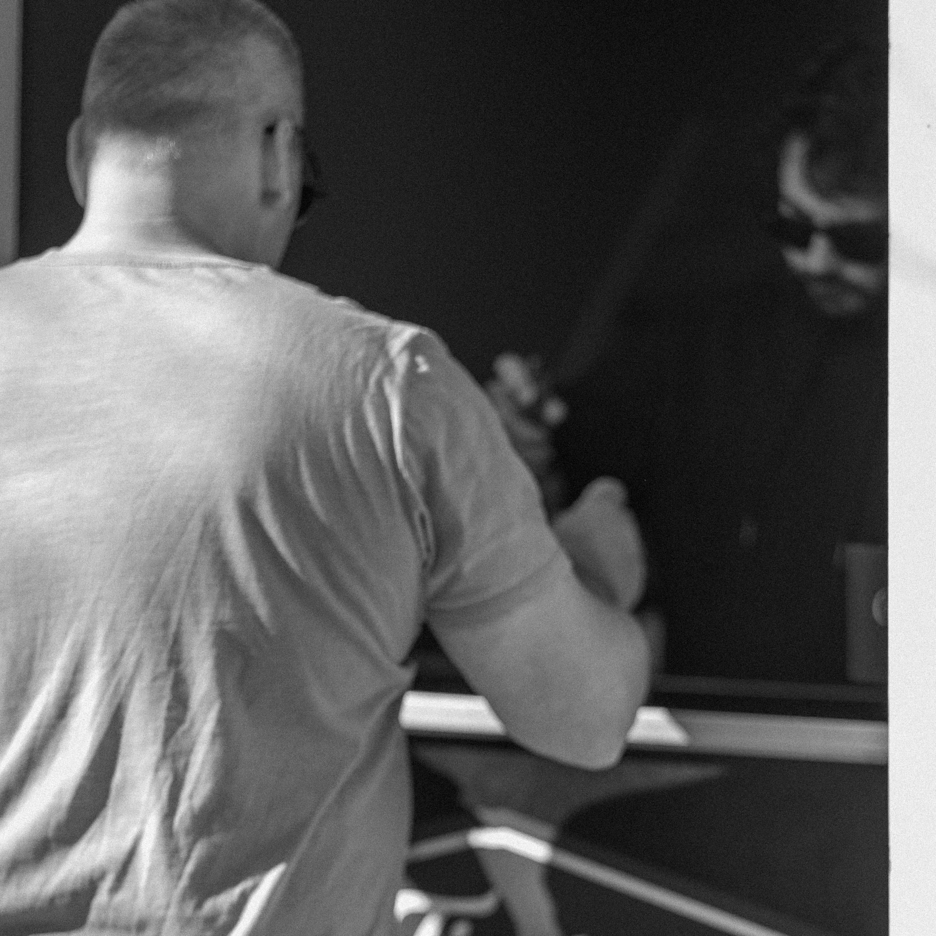 A person seen from behind at a counter, in black and white