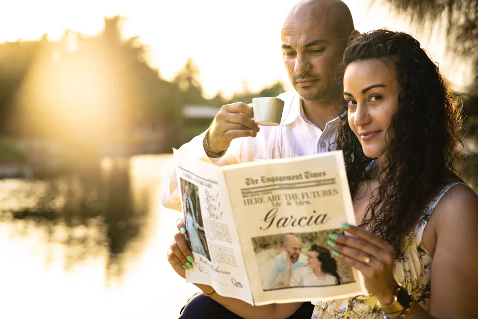 Couple reading a newspaper beside a lake